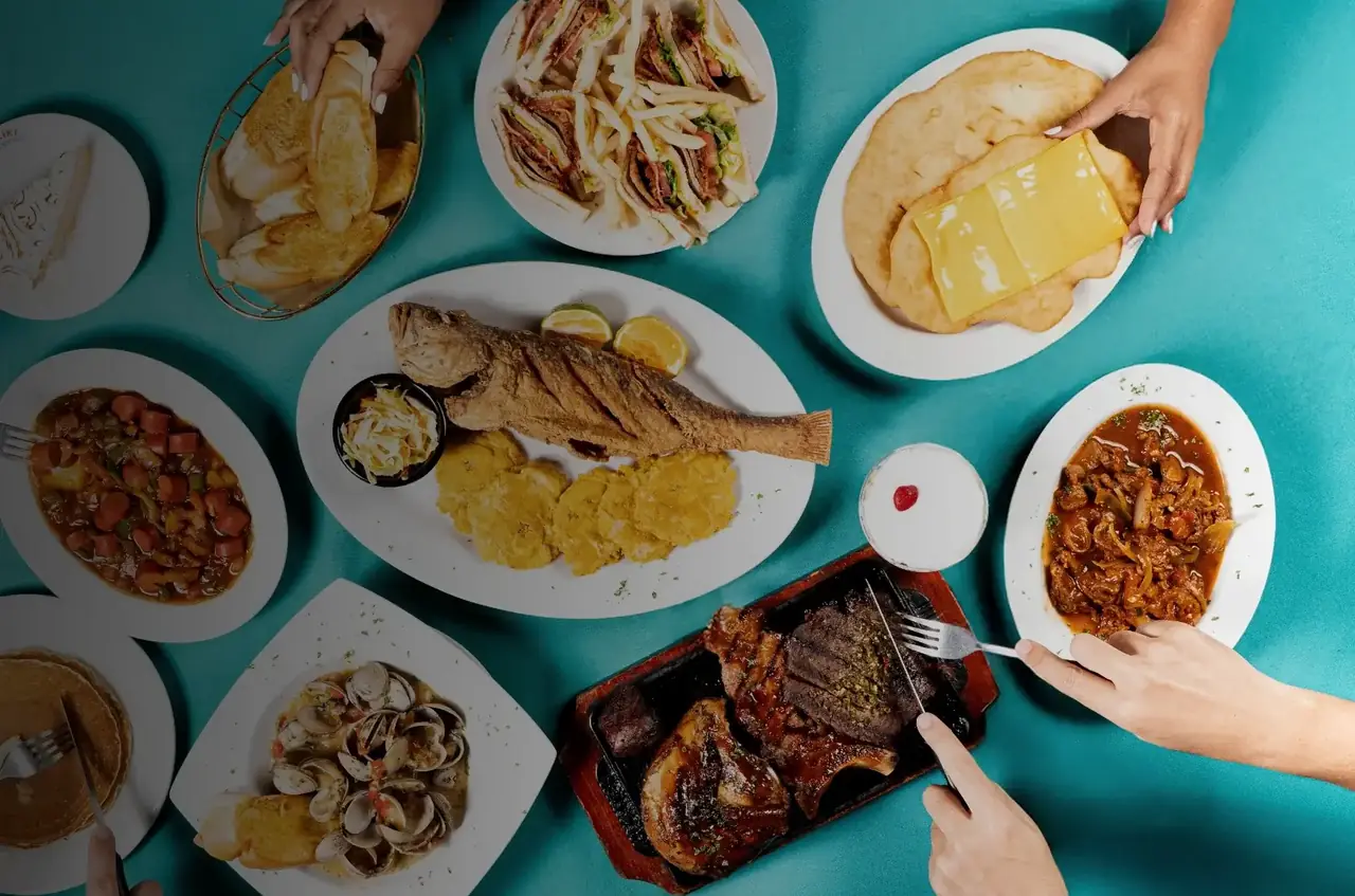 Mesa de Waikiki con corvina frita, patacones, hojaldres, sándwich club y almejas